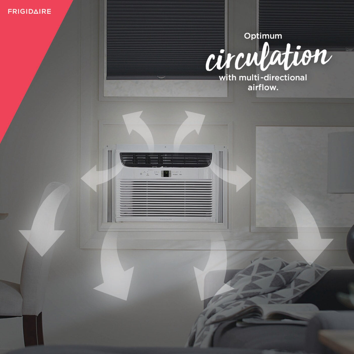 Frigidaire window air conditioner installed in a living room, illustrating 'Optimum circulation with multi-directional airflow' with white arrows showing air movement. Ideal for efficient room cooling and even temperature distribution.