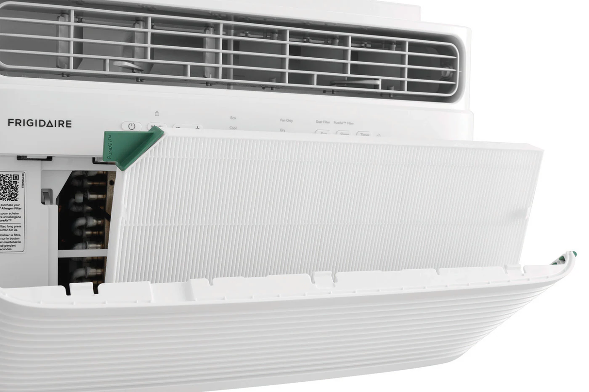 Close-up view of a Frigidaire FHWC064TE1 6,000 BTU Window Air Conditioner, with the front panel opened to reveal the white pleated PureAir Advance filter being inserted or removed. A green tab on the filter is visible for easy handling, demonstrating simple maintenance