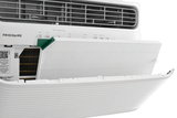Close-up of a Frigidaire 12,000 BTU Window Room Air Conditioner with Wi-Fi, model FHWV124TE1, with the front panel opened to reveal the white pleated PureAir Advance filter being inserted or removed. A green tab on the filter is visible for easy handling, demonstrating simple maintenance